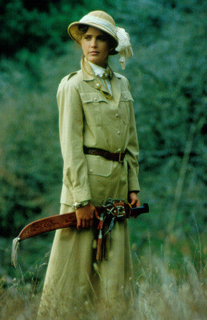 Woman standing in tall grass wearing 130 Jacket and 209 Walking Skirt. Model holds an machete in hands and wears a sun hat.