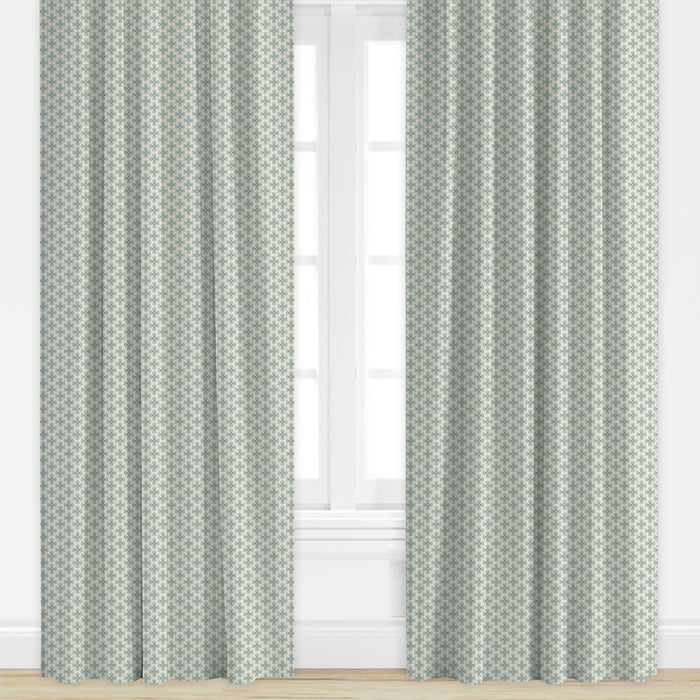 Patterned curtains in blue by Camilla Moss on a window with a light background