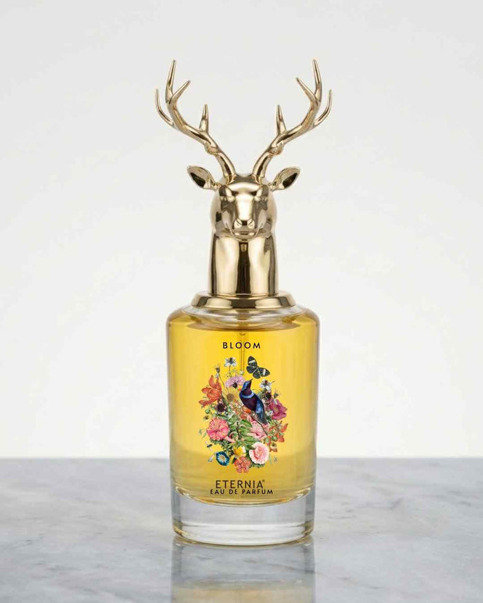 Eau de Parfum bottle with gold deer-antler cap and yellow floral label