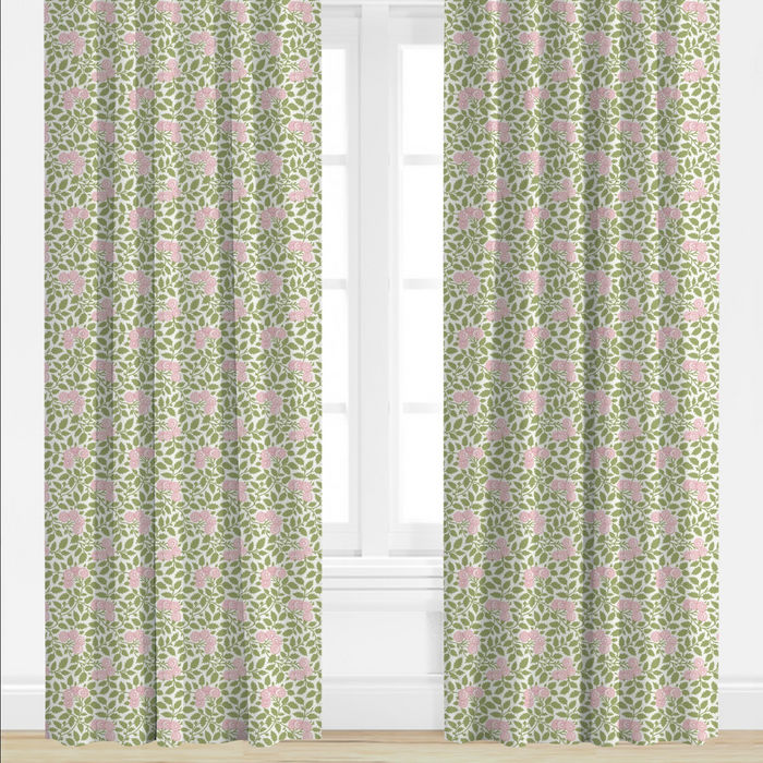 Green curtains with pink floral pattern in a room with white walls and window blinds.