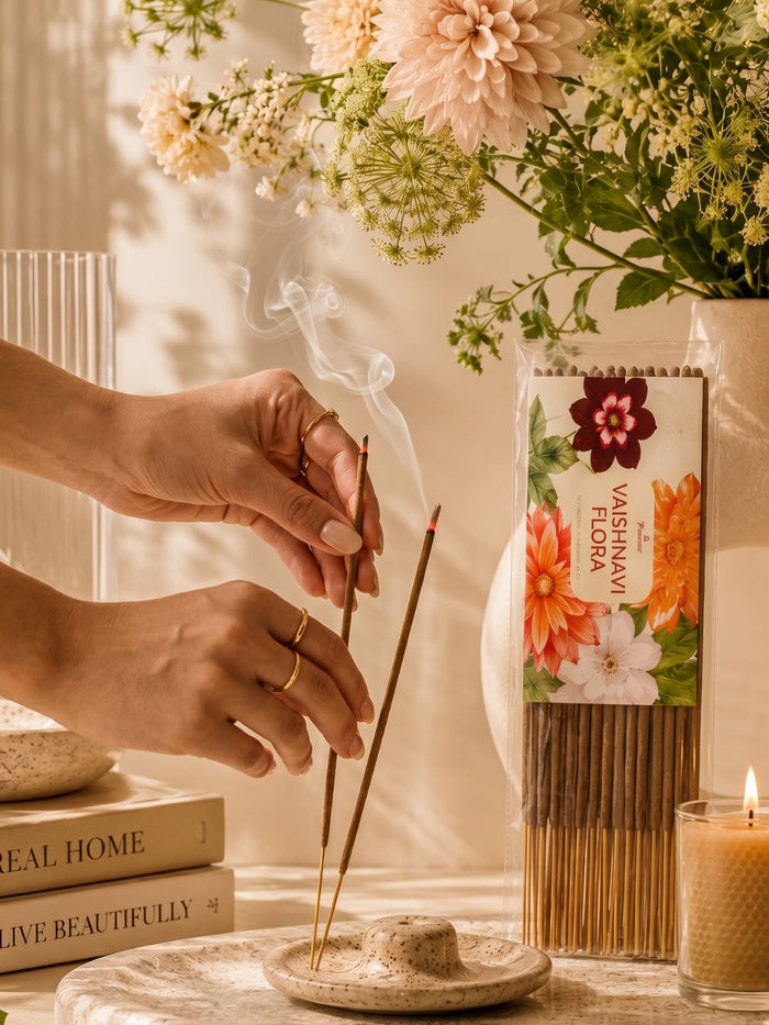 Floral incense sticks being lit with smoke above a clay burner