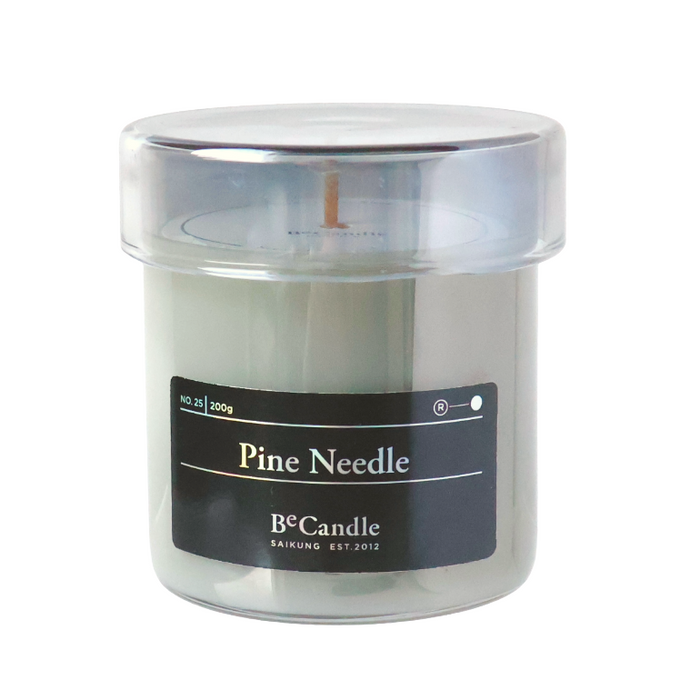 Candle in a clear container with a black label on a white background