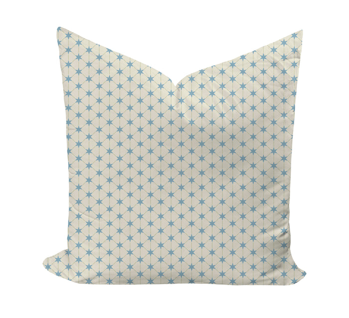 A square throw pillow with a cream background and a repeating light blue starburst geometric pattern, shown against a plain white background.