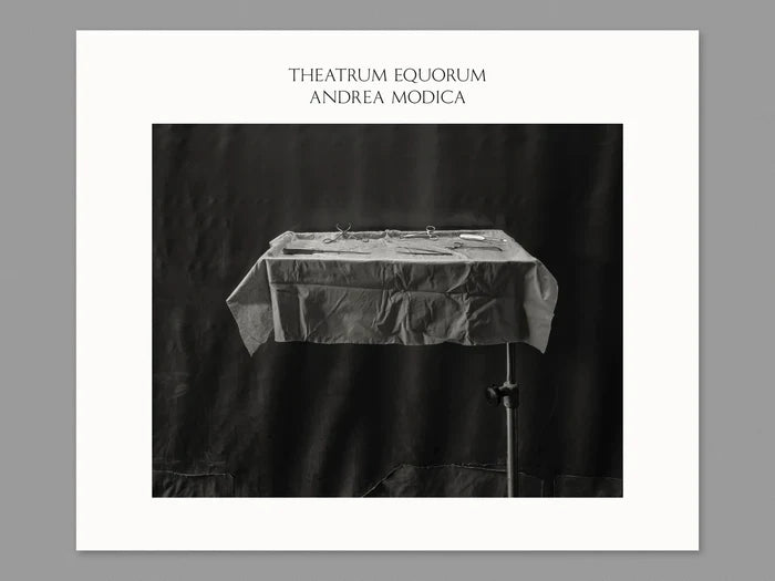 black and white image of table with tablecloth and medical instruments on top