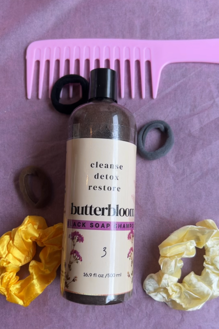 African black soap shampoo by Butterbloom for hair growth, shown in a clear bottle with black soap ingredients and natural packaging.