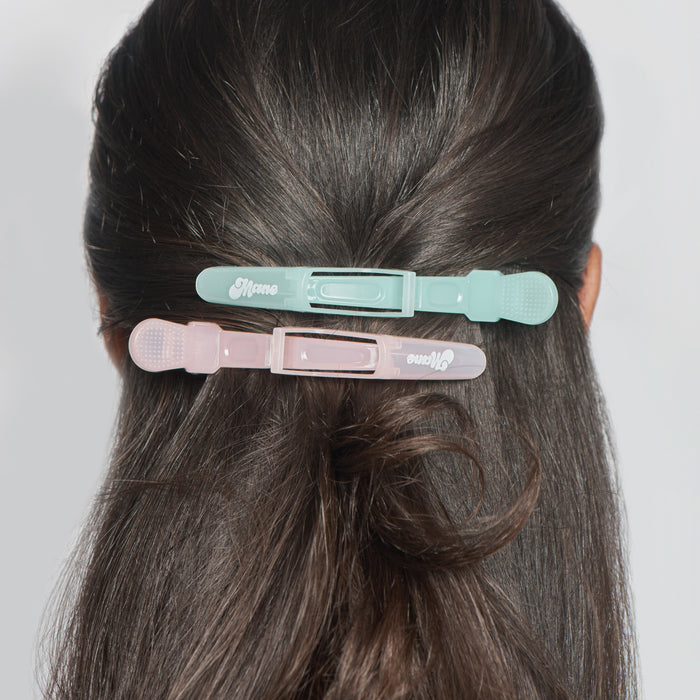 Two hair clips on a person's head with a plain background