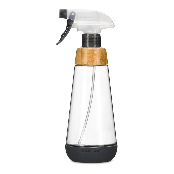 A Full Circle clear glass spray bottle with a black trigger sprayer, a light brown bamboo wood collar, and a dark grey silicone base, shown on a plain white background. Eco-friendly refillable spray bottle.