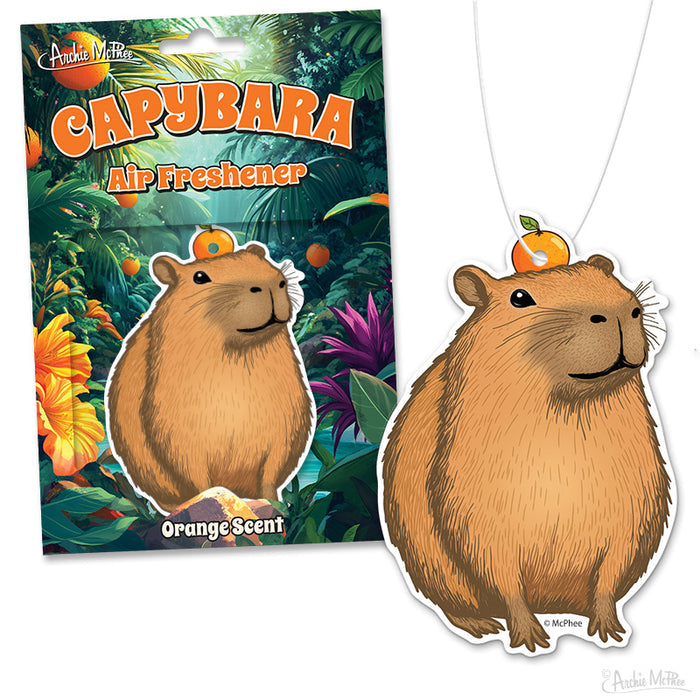 The Capybara Air Freshener features a capybara shape with an orange on its head, has an orange scent, and comes in tropical-themed packaging.