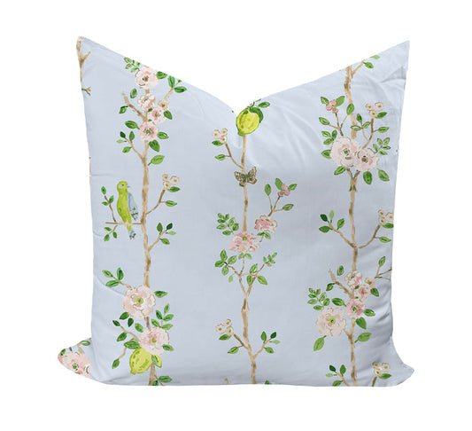 Decorative pillow with floral and bird pattern on a light blue background