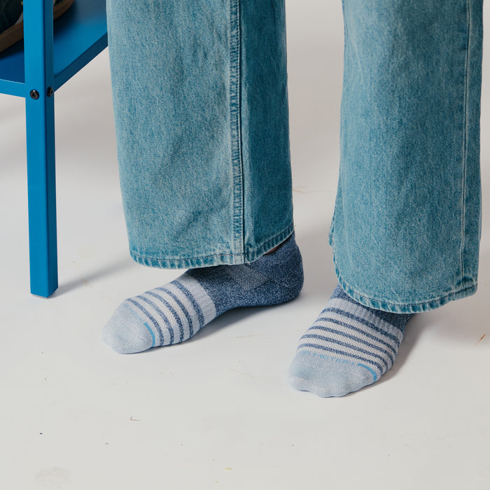Ankle compression socks with a contrast stripe design, worn with light blue jeans.