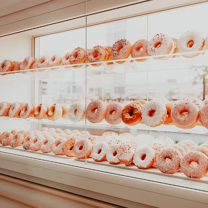 A display case filled with rows of assorted donuts.