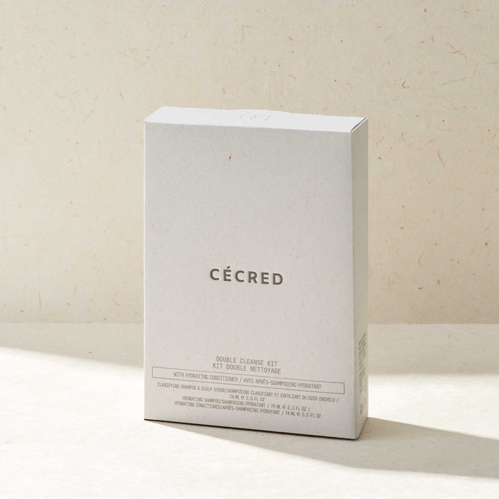 Cécred Double Cleanse Kit with Hydrating Conditioner minimalist white box standing upright on a warm beige surface, front-facing to display the Cécred logo and product contents listing