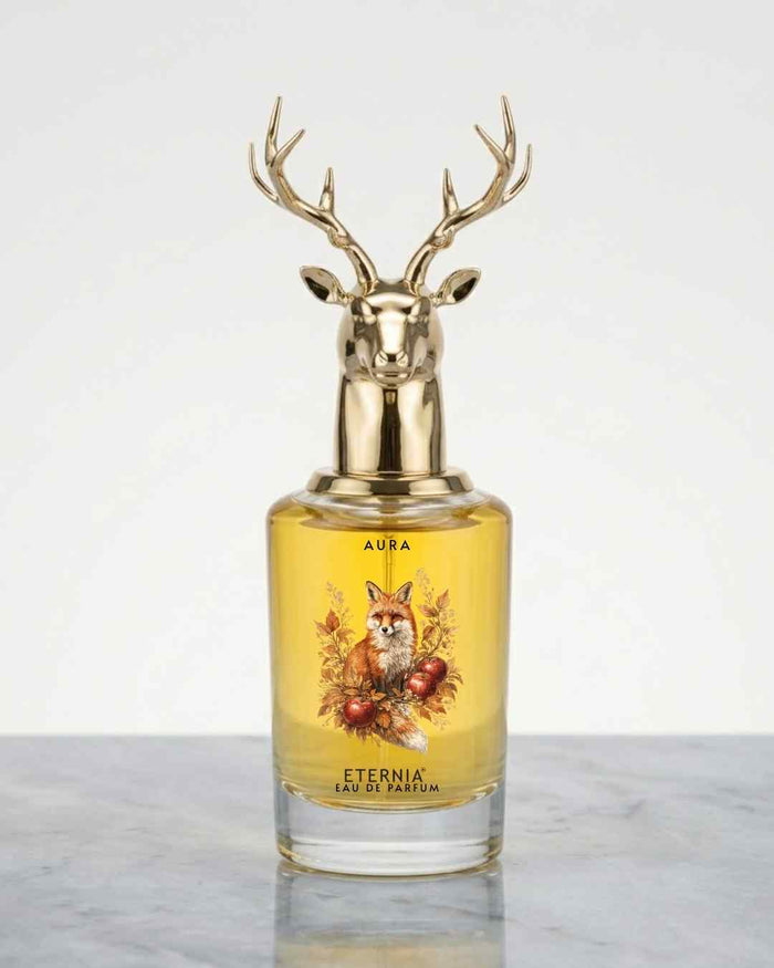 Glass eau de parfum bottle with gold deer antler cap, yellow liquid, front labels