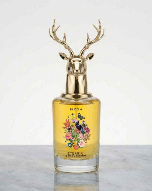 Eau de Parfum bottle with gold deer-antler cap and yellow floral label