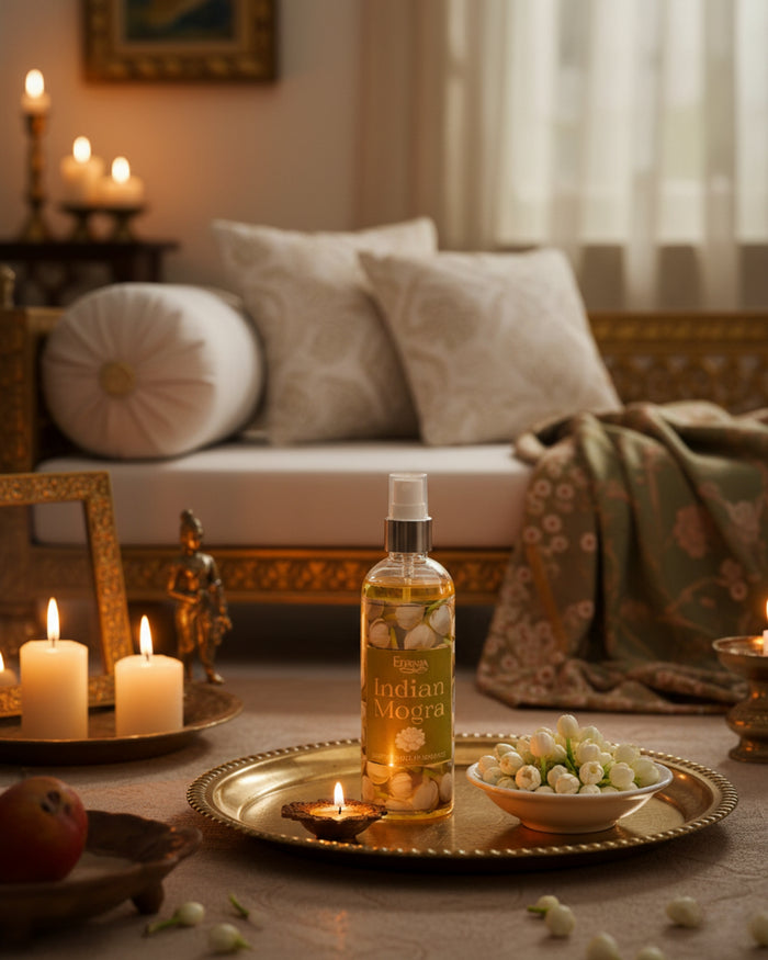 Indian Mogra room spray bottle centered on a tray with candles and flowers around.