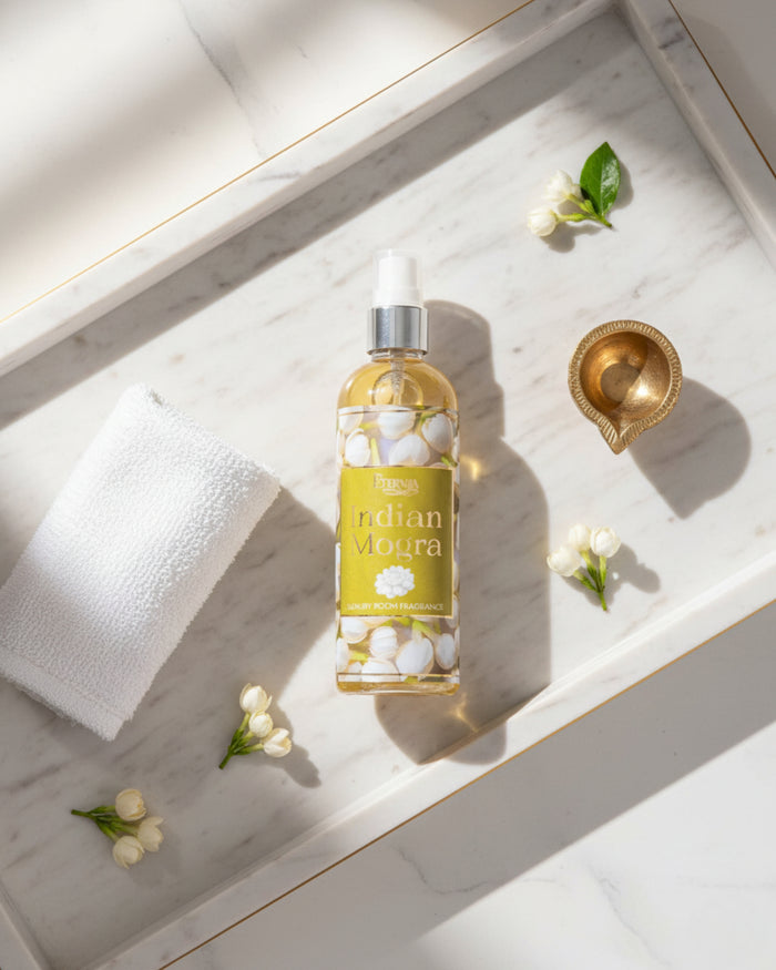 Indian Mogra room spray bottle with silver sprayer, placed on white marble with petals.