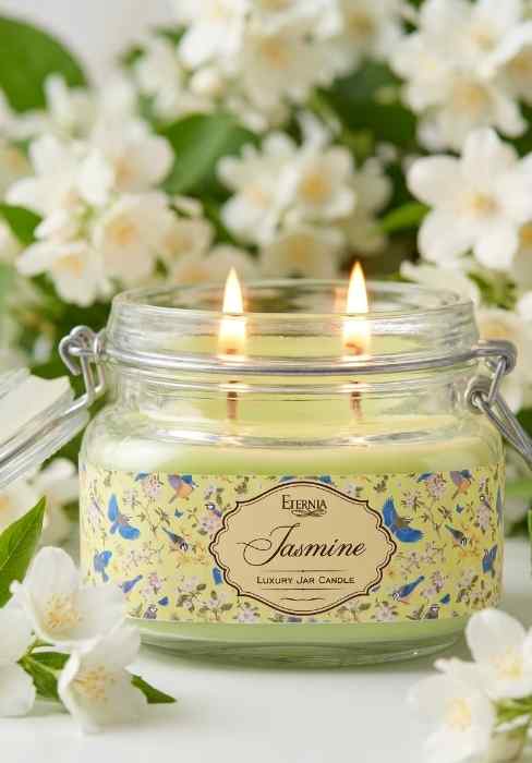 Eternia® Jasmine double-wick jar candle in clear glass jar with two lit wicks