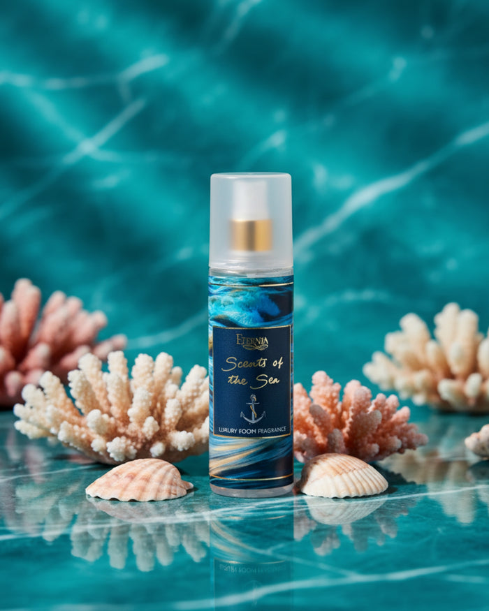 Luxury room spray bottle with white cap and blue wave label, near seashells.