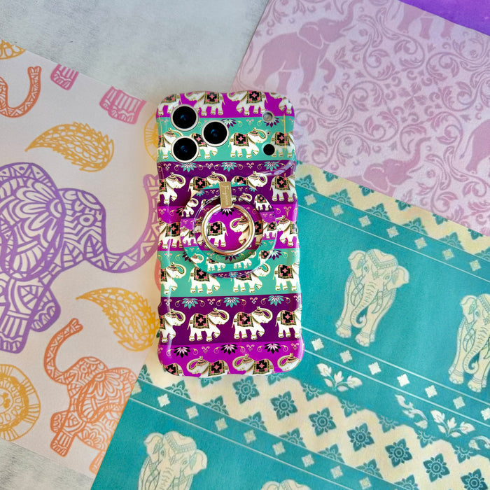 Fortune Parade Wavy Luxe iPhone case with the matching MagSafe grip ring attached, styled on lilac damask and elephant print paper.
