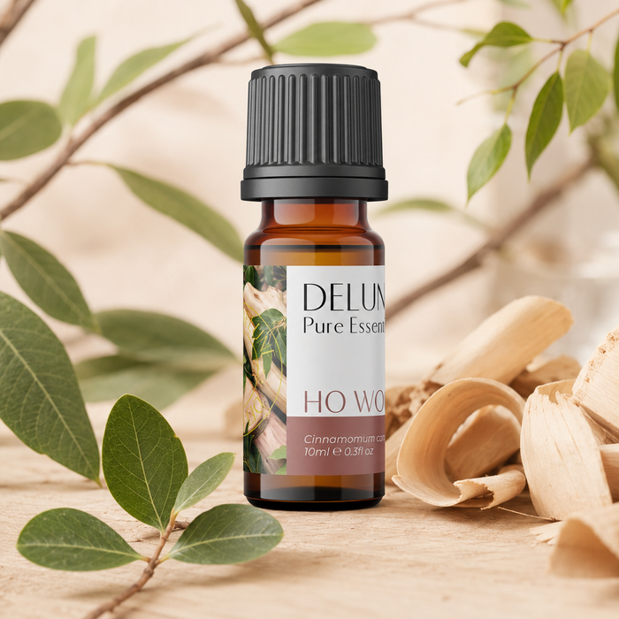 Ho Wood Pure Essential Oil with aromatic wood shavings and green foliage