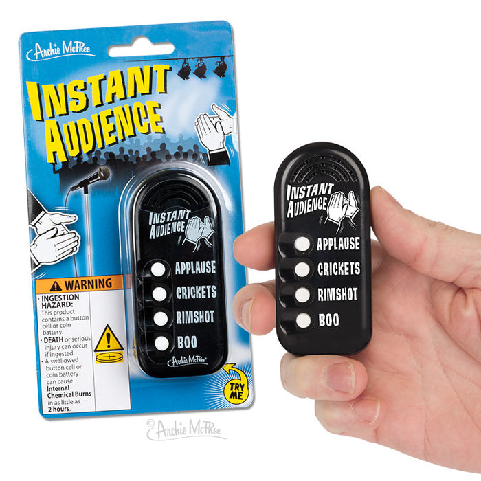 A hand holds an Instant Audience noisemaker, which is an electronic feedback device that includes buttons for sound effects like applause, crickets, rimshot, and boo—perfect for creating instant sound effects.