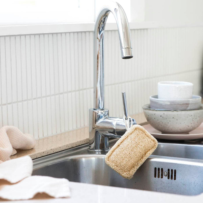 Ever Eco Loofah Dish Sponge styled in a kitchen sink hanging from its loop on the tap.