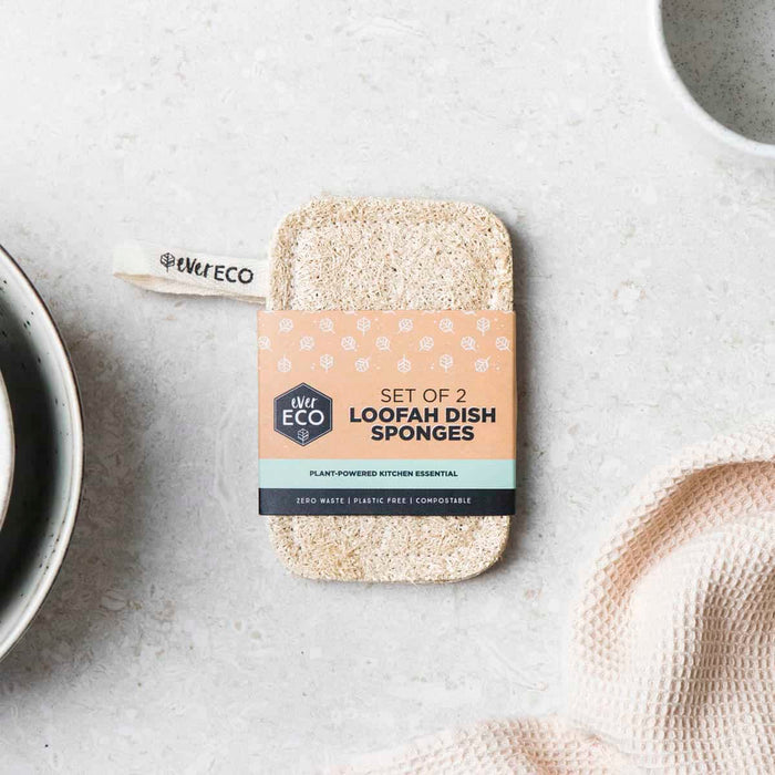 Set of 2 Loofah Dish Sponges pictured with packaging on a marble bench with textural elements.