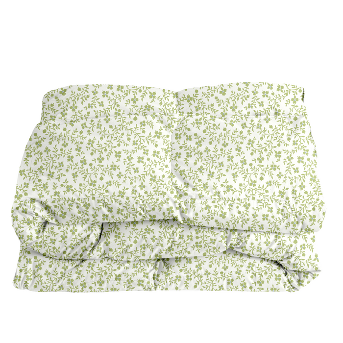 Folded floral comforter in green on a white background