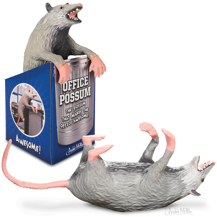 A stuffed latex Office Possum is perched on an illustrated box, with another one lying on its back, both showcasing pink tails and posable paws.