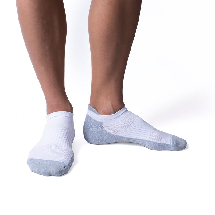 Ankle compression socks in white and gray, worn on a person's feet, showing ribbed and mesh textures.