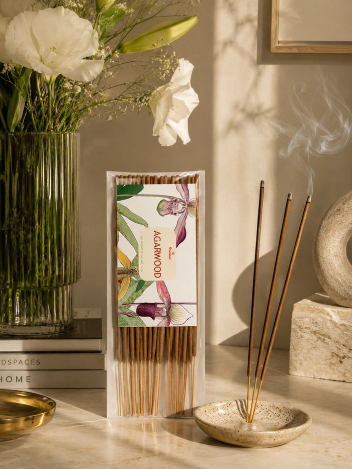 Agarwood scented incense sticks pack with several unlit sticks beside a small incense bowl