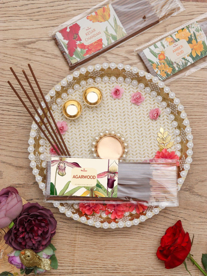 Agarwood scented incense sticks pack on a decorative tray with scattered sticks