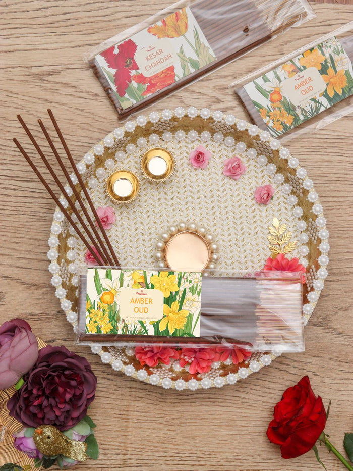 Amber oud agarbatti incense sticks pack, shown with loose sticks and floral box