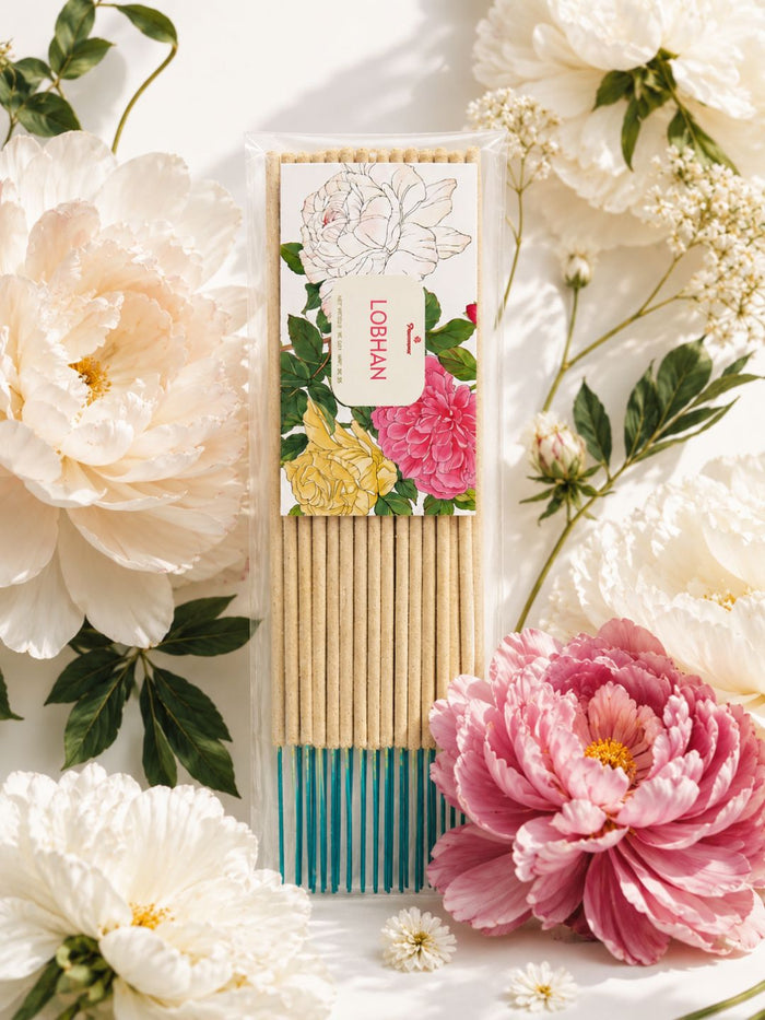 Pack of traditional incense sticks with floral artwork and teal-striped bottom