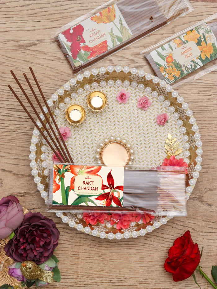 Incense sticks pack with floral label, loose wooden sticks, and decorative white tray
