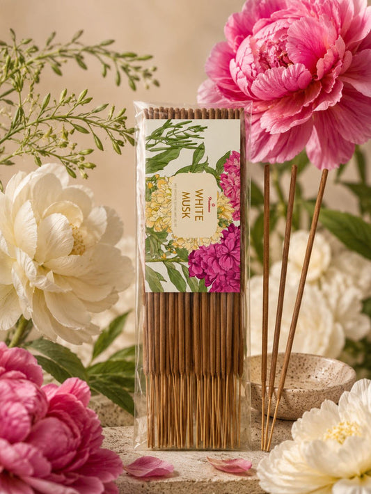 Agarbatti incense sticks in floral box beside standing wooden sticks with pink and white flowers