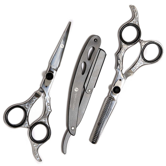 Three silver and black barber tools are arranged on a white background: straight scissors, a folding razor, and thinning scissors.