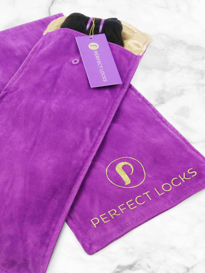 A vibrant purple suede pouch with a gold Perfect Locks logo and tag on white marble, partially open to reveal barber shears inside.