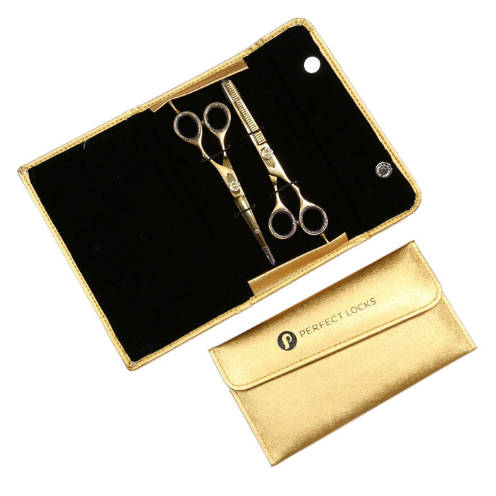 A sleek gold case with black interior holds hair cutting scissors and thinning shears; a closed gold “Perfect Locks” case sits beside it.