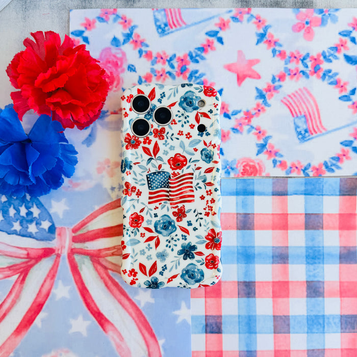 Trendy wavy iPhone case featuring an American flag illustration surrounded by a red and blue watercolor floral pattern with a high-gloss finish.