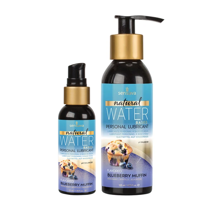 Two dark bottles of Sensuva Natural Water Based personal lubricant are displayed side-by-side against a white background. Both feature vibrant blue and purple labels with gold accents and an illustration of a blueberry muffin with fresh blueberries.