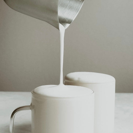 Steamed milk being poured into a cup