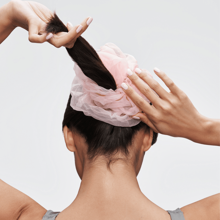 Woman tying hair with pink Sugar Cloud Scrunchie XL