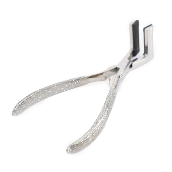 A pair of silver pliers with textured, glittery handles and flat, rectangular tips rests on a white background.