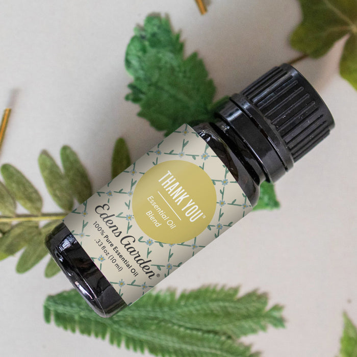 Thank You essential oil bottle with botanical leaves in behind it