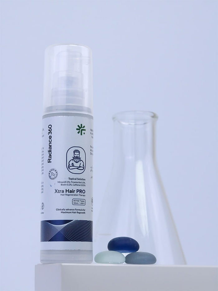 Bottle of Xtra Hair PRO with a beaker and stones on a light gray background